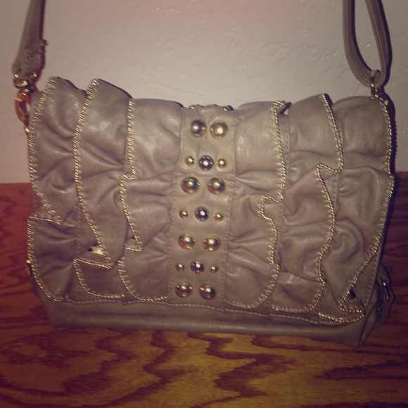 Grey purse with gold zipper ruffles and design.