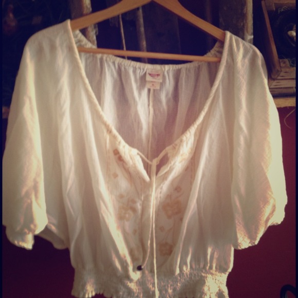 Cream colored sheer top with flowy arms.