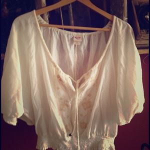 Cream colored sheer top with flowy arms.