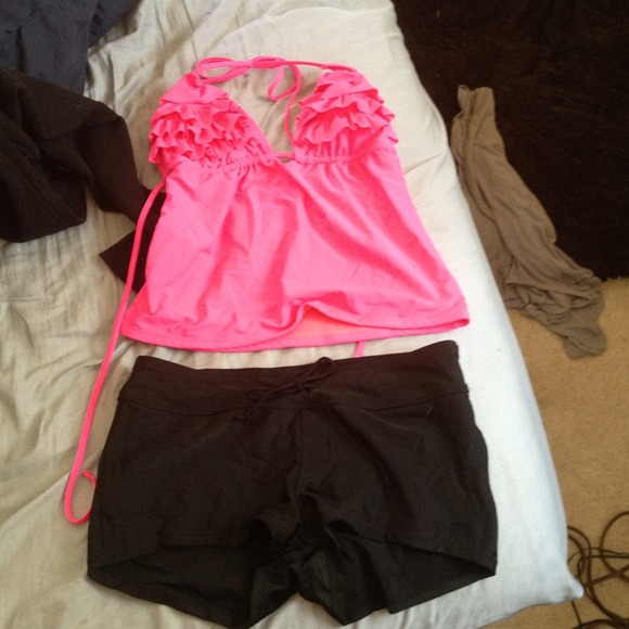 Pink tankini top and black swim shorts