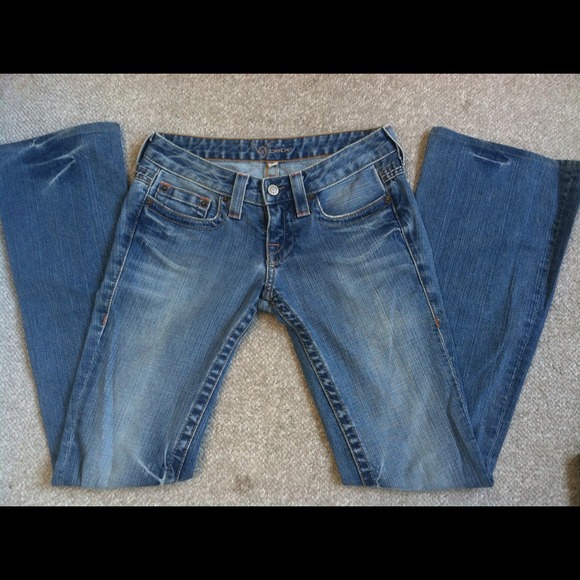 Bebe denim, light-washed flare with snap pockets.