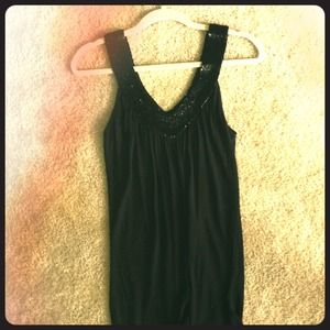 Black top with a beaded V-Neck collar.