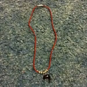 A red bead dolphin necklace