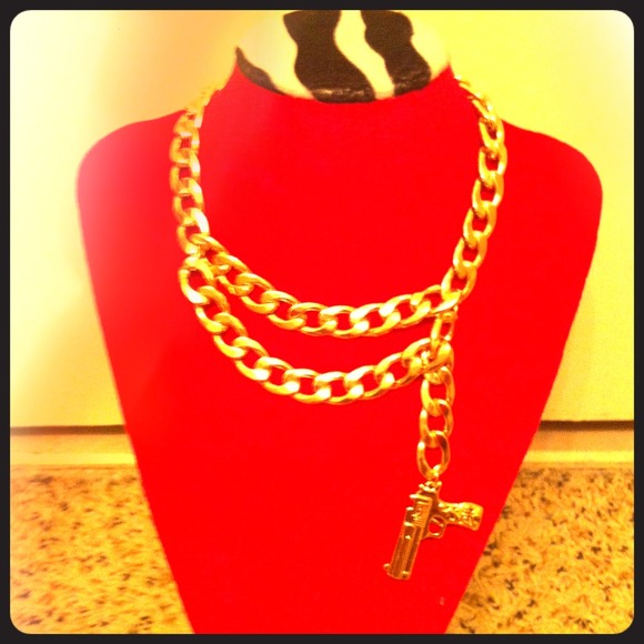 Gold link necklace with pistol.