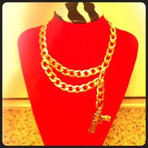 Gold link necklace with pistol.