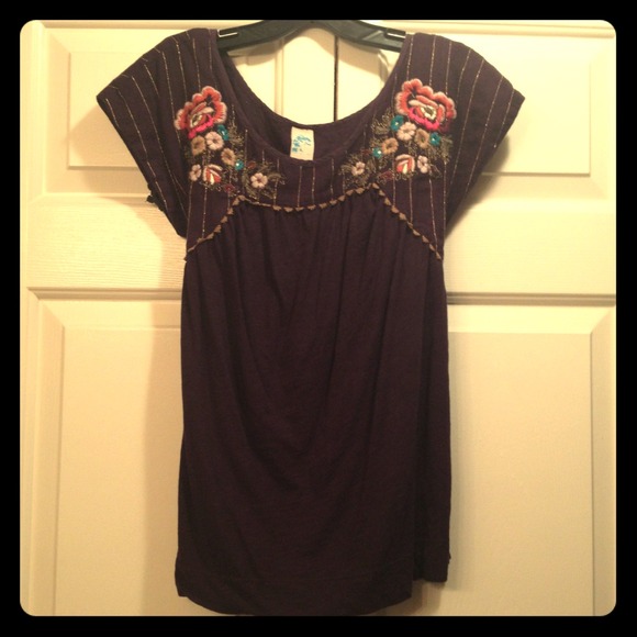 Dark purple top with cute flower embellishment.