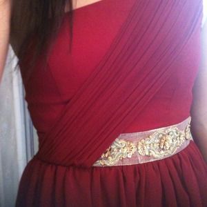 Red one shouldered dress with gold detail on waist