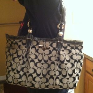 Coach purse, black cloth with a top zipper.