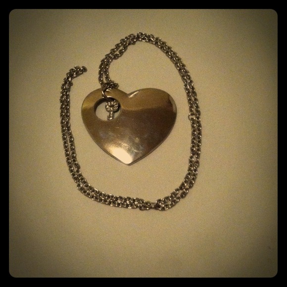 Long silver necklace with key inside heart