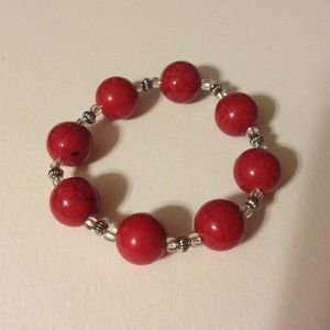 Red and silver bracelet on a jewelry elastic