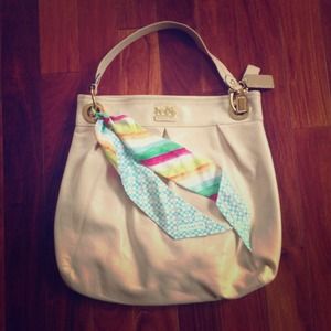 Light tan Coach bag with rainbow bag scarf