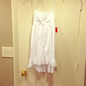 White sun dress, slightly longer in the back.