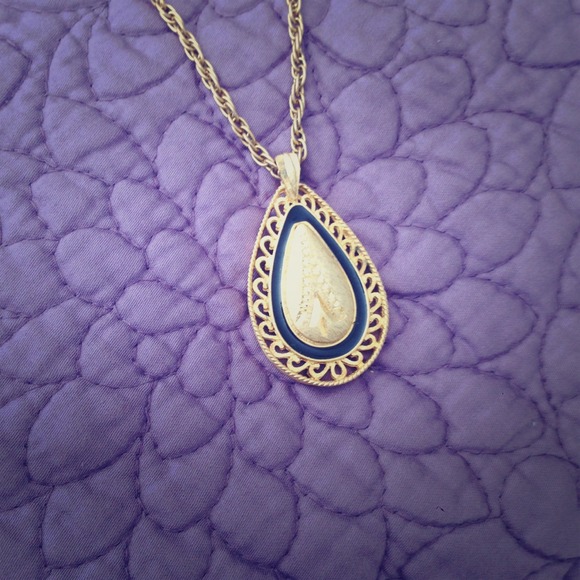 Vintage gold chain with gold and black pendant.