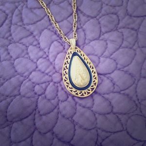 Vintage gold chain with gold and black pendant.