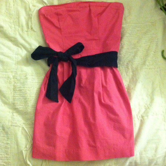 Short pink dress with blue bow belt.