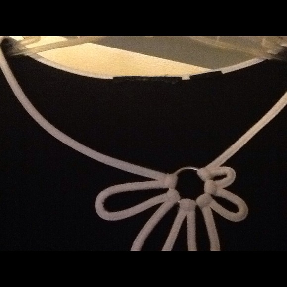 Black blouse with white detail with silver hoop.