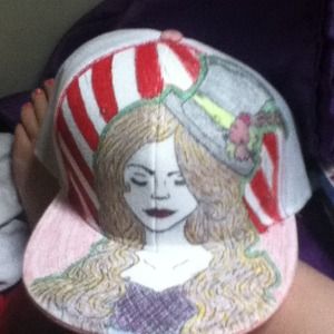 White flat bill hat, drawn on. Circus themed