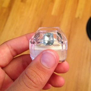 Silver ring with light-blue stone in center.