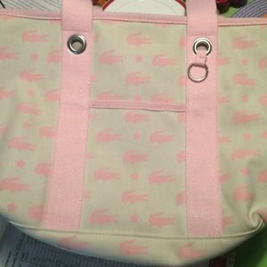 Off white with pink Lacoste symbols. Purse