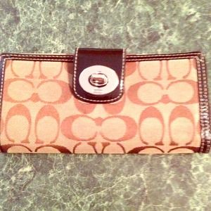 Tan coach wallet with bronze lettering