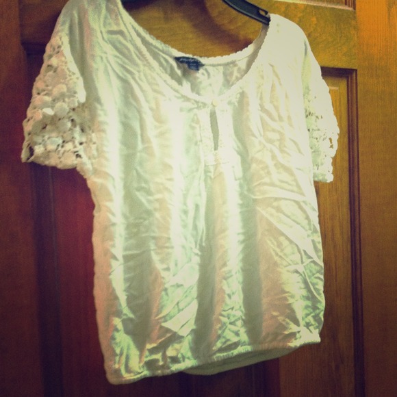 White shirt. Flower design on sleeves.
