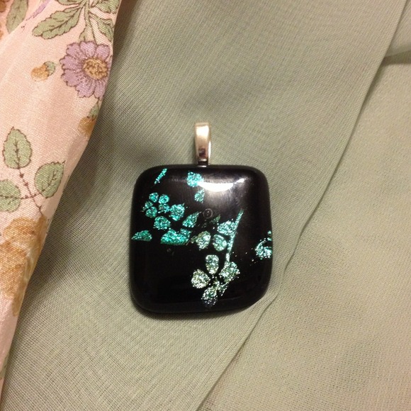 Black pendant with teal design inside