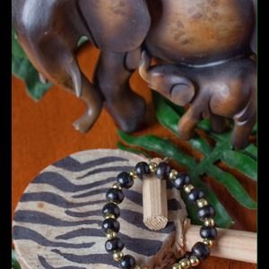 Black wooden beads, gold beads and a black cross.