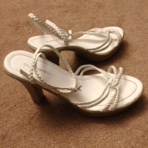 White sandals, ankle straps double around ankle.