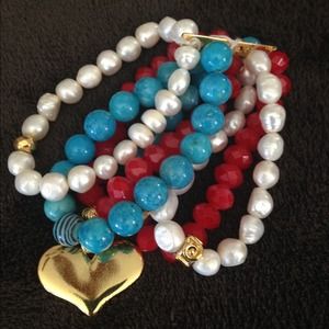 White, blue and red bracelet with gold heart.