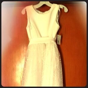 White flower girls dress with tags still on it.