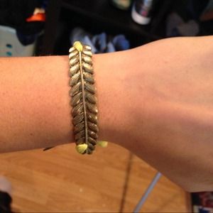 Gold feather bracelet. With green strings