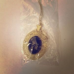 Black pendant long gold necklace.