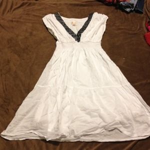White dress with black trim around v-neck