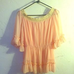 A sheer pink blouse with a crochet neck line.