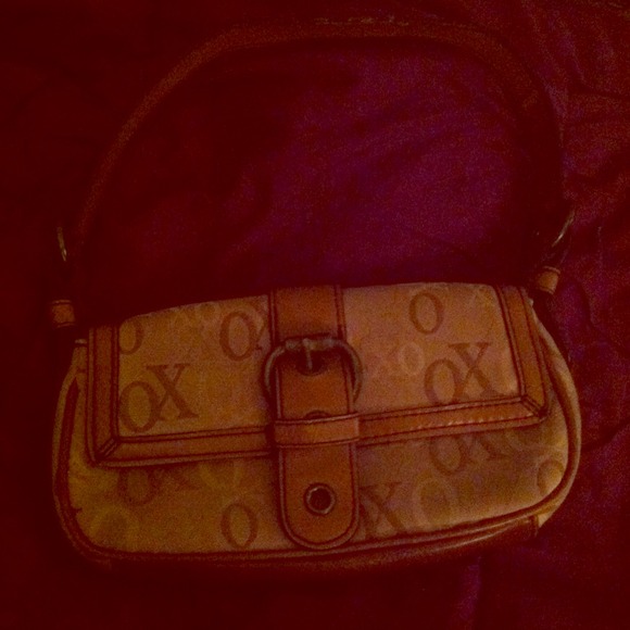 Brown xoxo purse with an adjustable buckle .