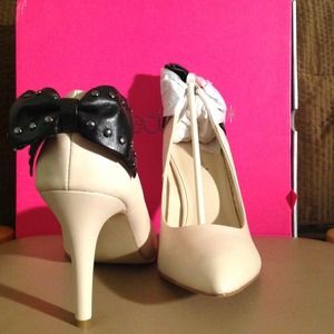 Off-white/tan high heel with bow detail.