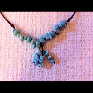 Black Macrame holding Turquoise bead necklace