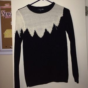 Black and white sweater with pearl designs.