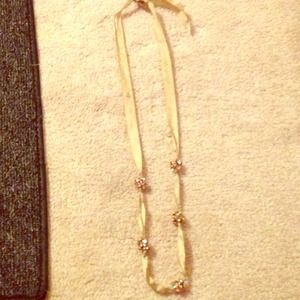 long ribbon necklace with pink rounded jewels.