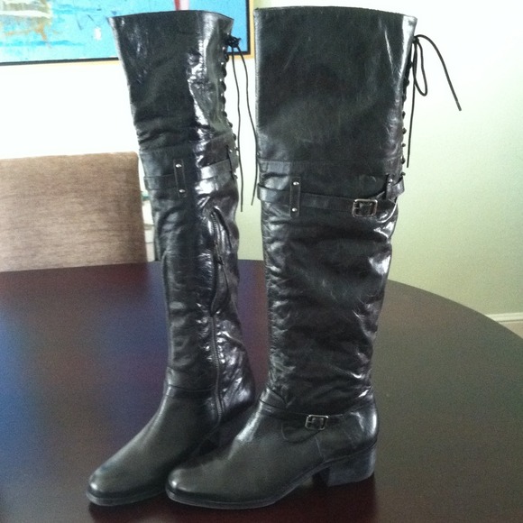 Tall Black boots to knee. Stitched up with buckle