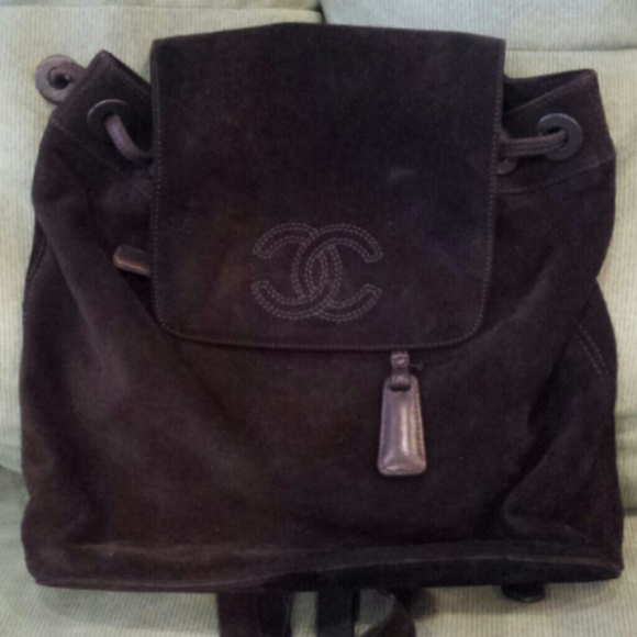 Holding Authentic brown suede Chanel backpack.