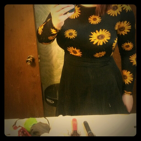 A sunflower long sleeve shirt amd black skirt