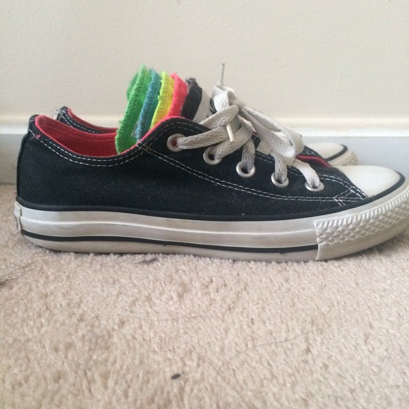 Black converse with multicolored tongues.