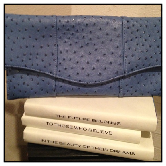 Textured periwinkle clutch with a removable strap.