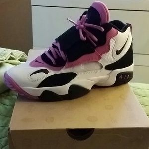 White, black and pink Nike Air speed turfs.