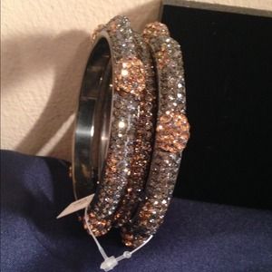 A set of 3 Pave Crystal Bangles with Gold Flower.