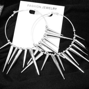 Silver toned , spiked earrings .