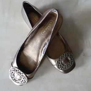 Coach gold flats. Small scuff on outer left shoe.