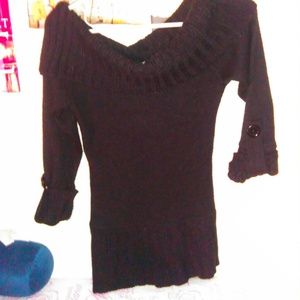 black long sleeve sweater hangs off the shoulder