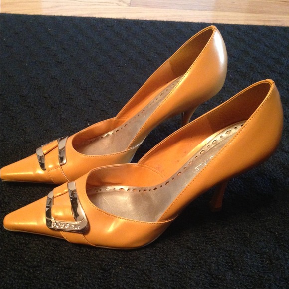 Orange BCBG shoes with gold buckle.